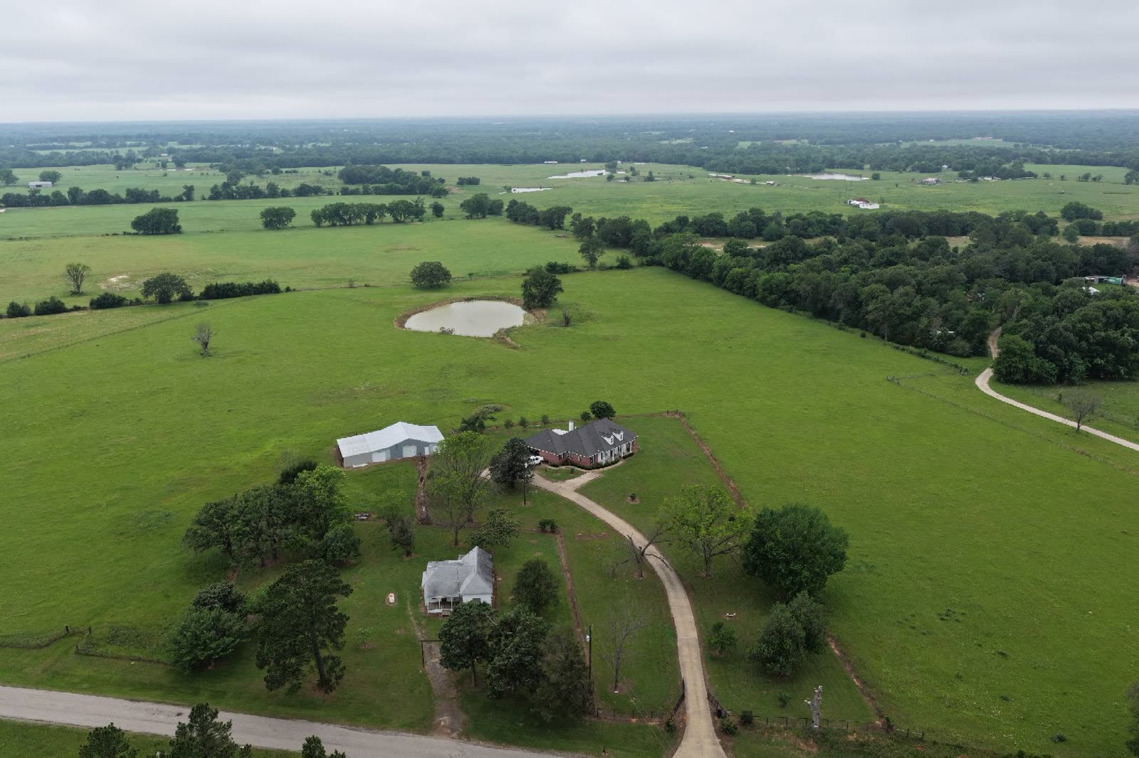 Aerial view of a farmhouse in green farmland